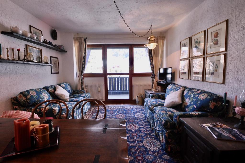 ein Wohnzimmer mit einem Sofa und einem Tisch in der Unterkunft Casa Colmet - Bilocale Spazioso La Thuile in La Thuile