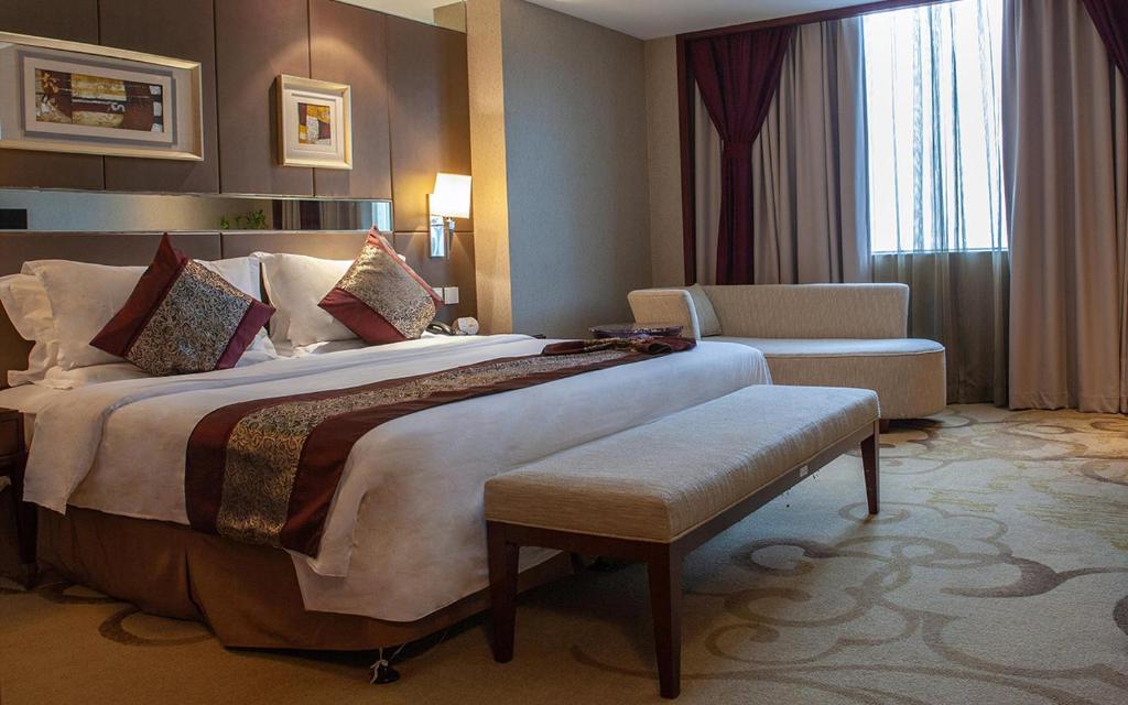 una habitación de hotel con una cama grande y una silla en Vision Hotel, en Beijing