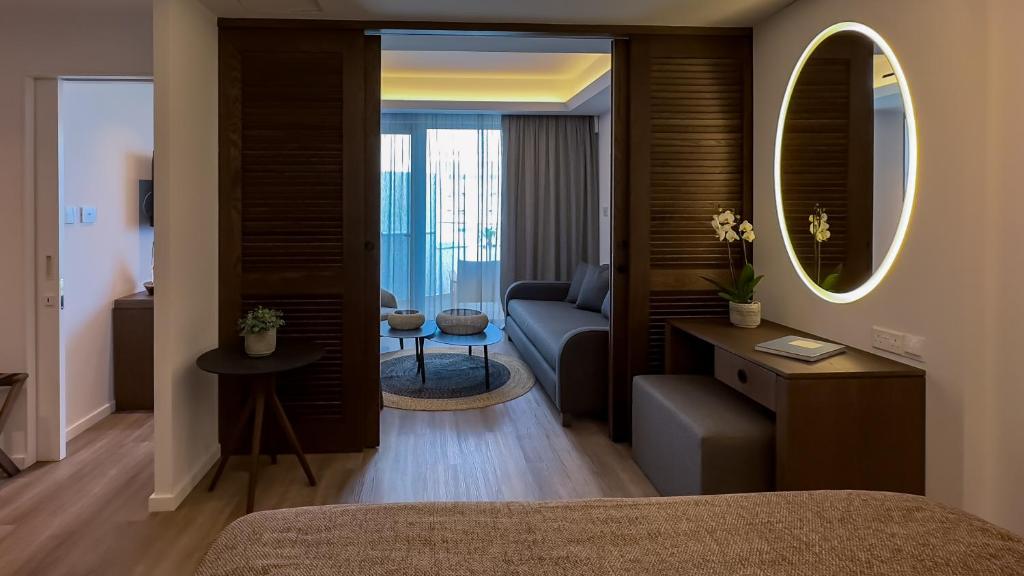 a bedroom with a couch and a living room at Tasia Maris Beach Hotel - Adults Only in Ayia Napa