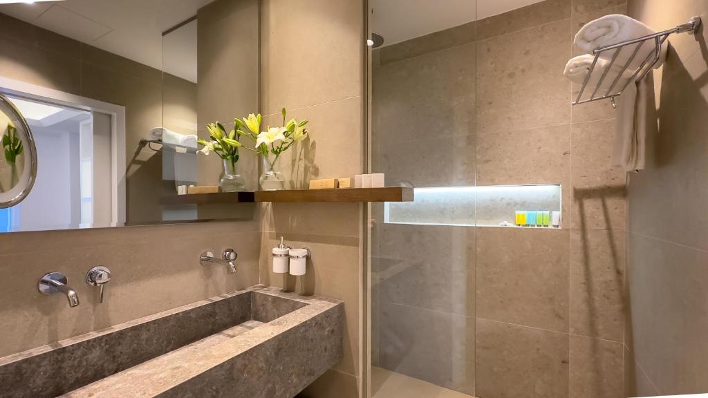 a bathroom with a shower with a sink and a tub at Tasia Maris Beach Hotel - Adults Only in Ayia Napa