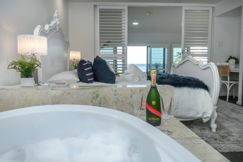 Villa by the Sea في ماندورا: زجاجة من النبيذ موضوعة على منضدة في غرفة النوم