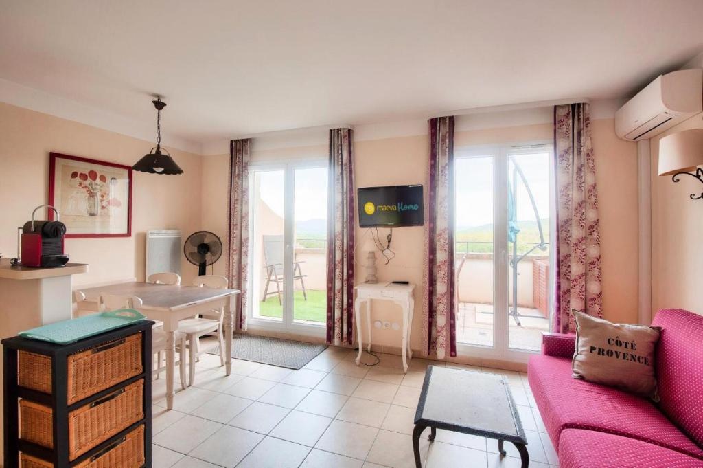 sala de estar con sofá rosa y mesa en Les Coteaux de Pont Royal en Provence - maeva Home - Appartement 2 Pièces 4 30, en Mallemort
