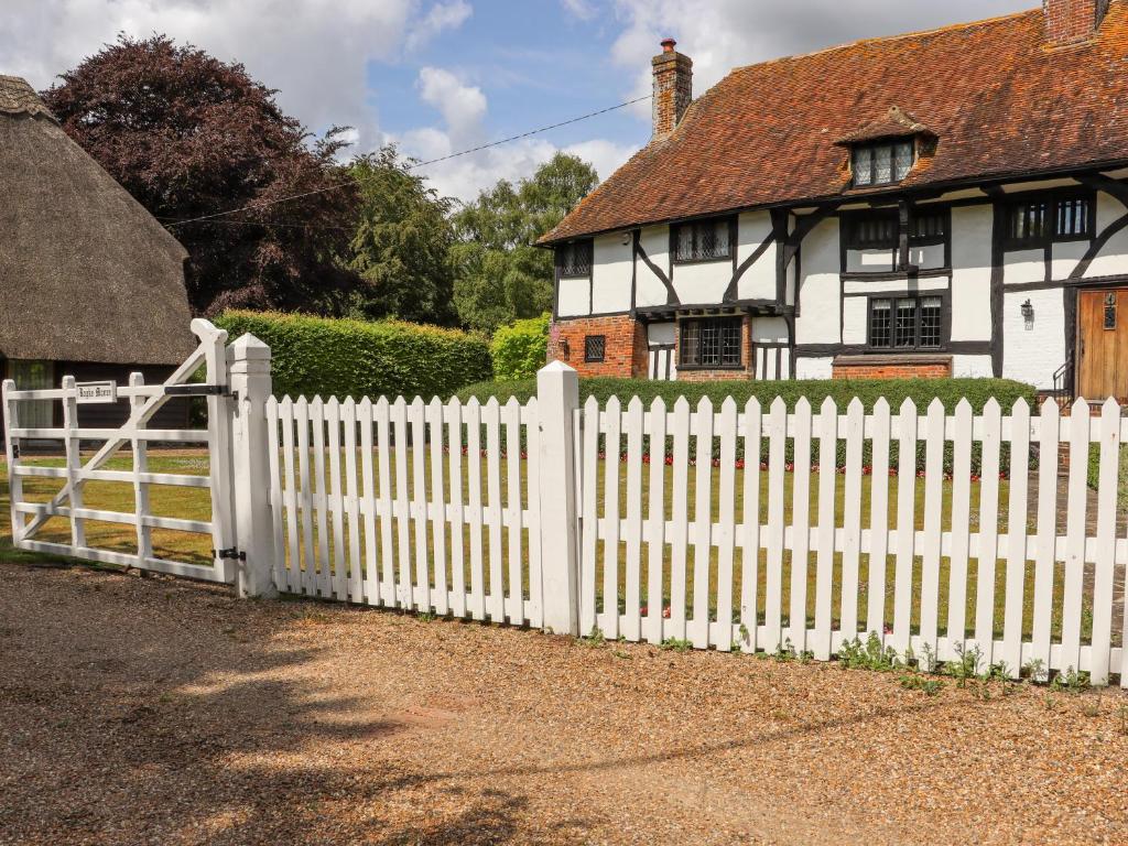 a white picket fence in front of a house at Wren Cottage in Canterbury