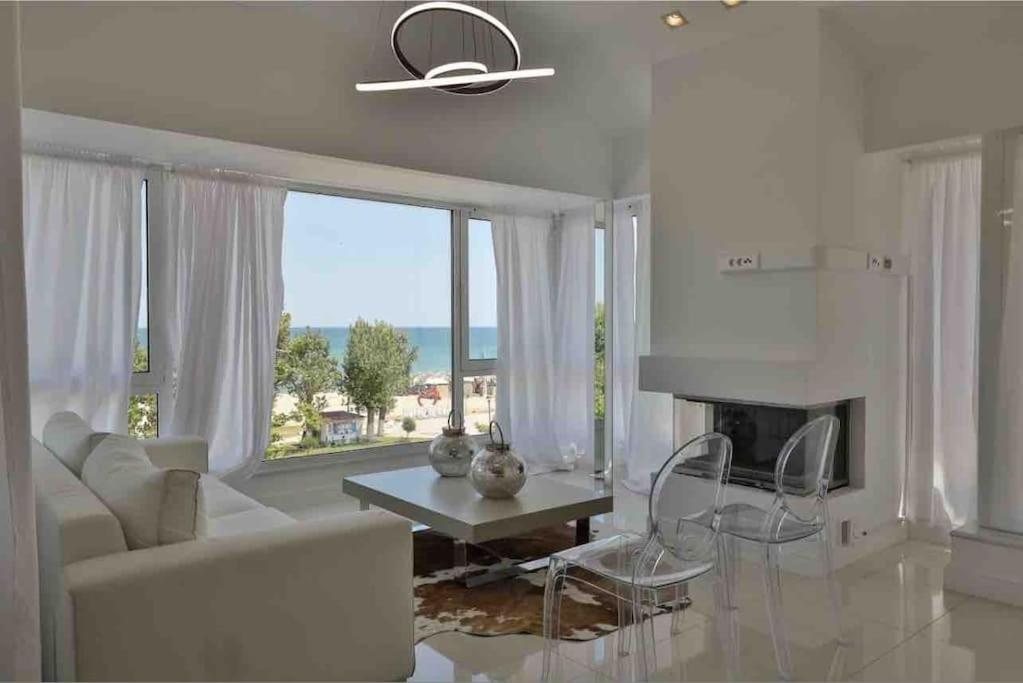 a living room with a white couch and a fireplace at Beach Apartment with Seaview II in Olympic Beach