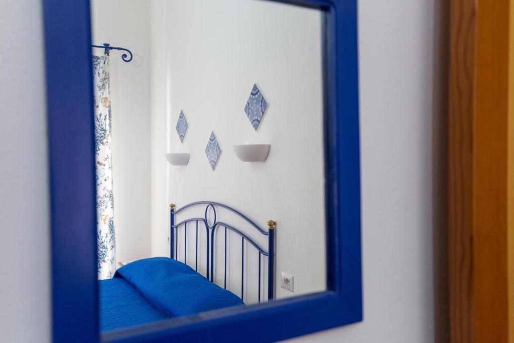 a mirror with a blue frame in a room at ALESSANDRAB&B in Lipari