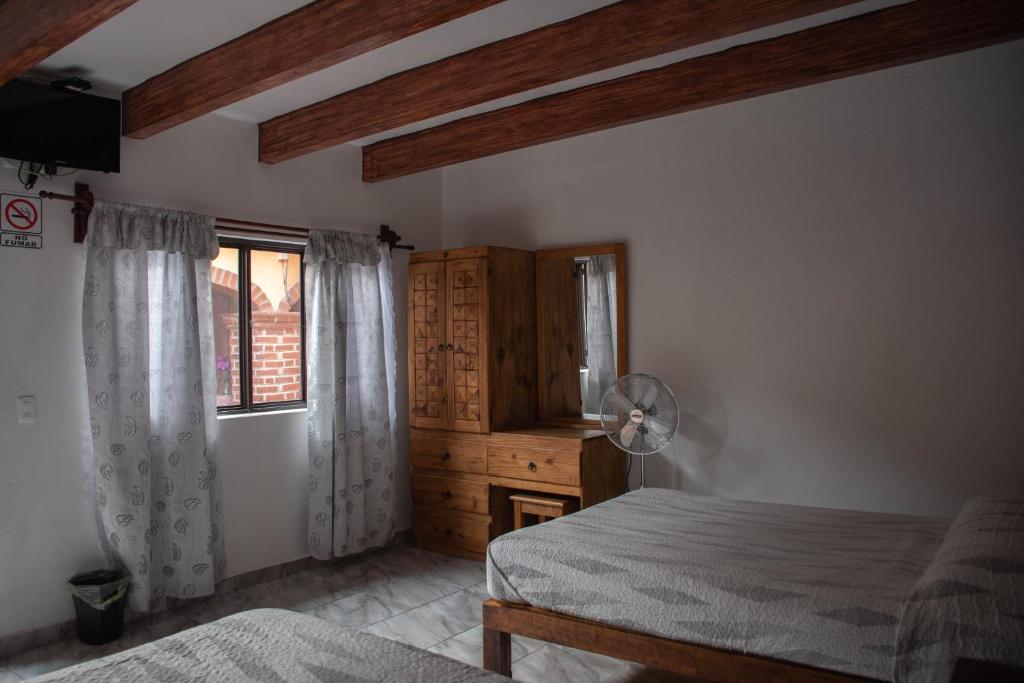 Un dormitorio con dos camas y una ventana en Hotel El Patio, en Tequisquiapan