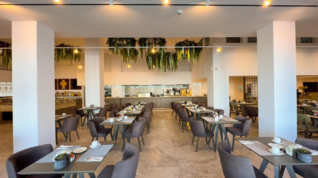 a restaurant with tables and chairs and a bar at Tasia Maris Beach Hotel - Adults Only in Ayia Napa