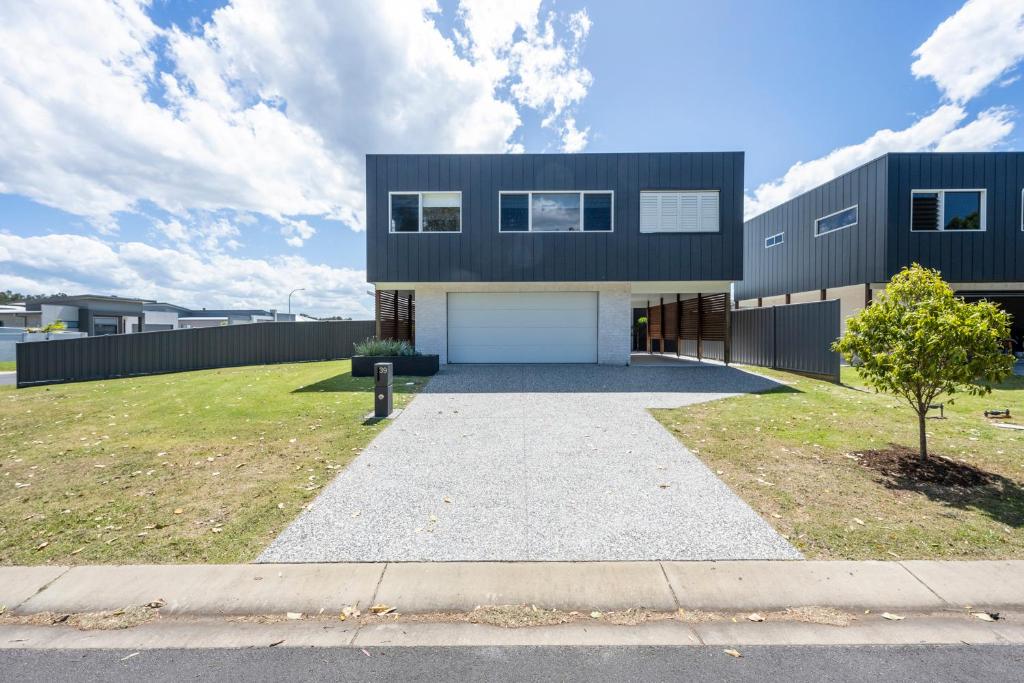 ein großes schwarzes Haus mit Auffahrt in der Unterkunft Aura Apartment-LJHooker Yamba in Yamba