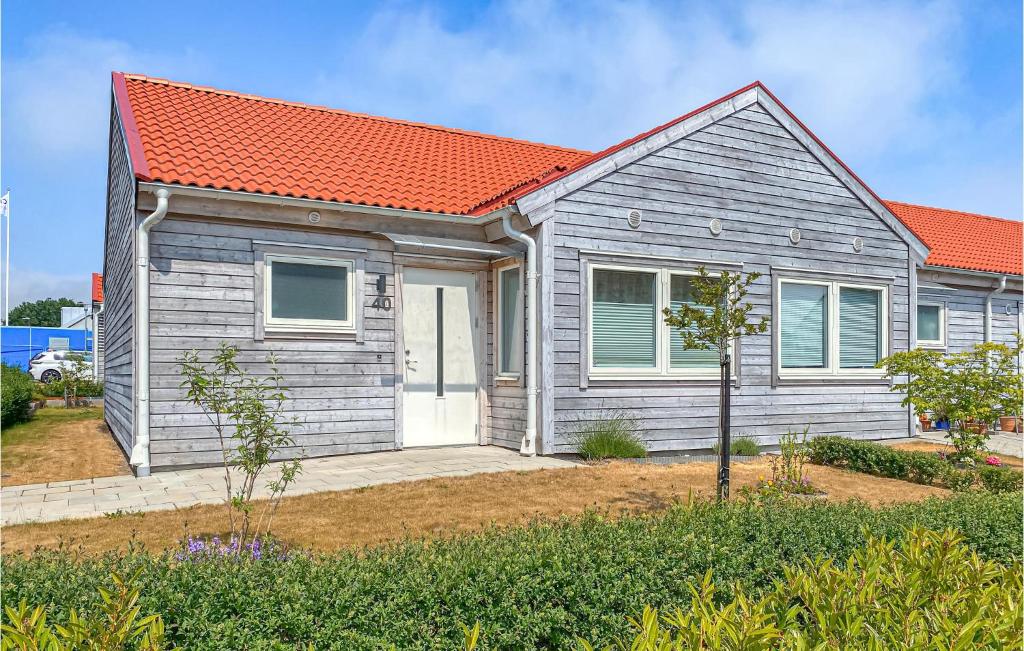 a gray house with an orange roof at Cozy Home In Simrishamn With Wifi in Simrishamn