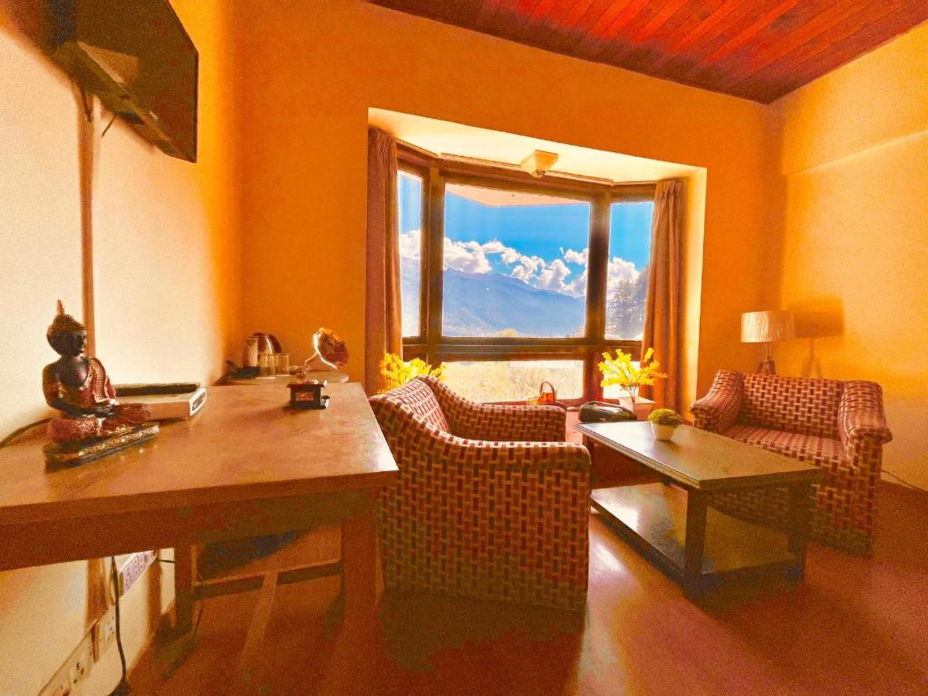 a living room with a table and chairs and a window at SAGAR RESORT JUST 5 MiN FROM MANALI MALL ROAD in Manāli