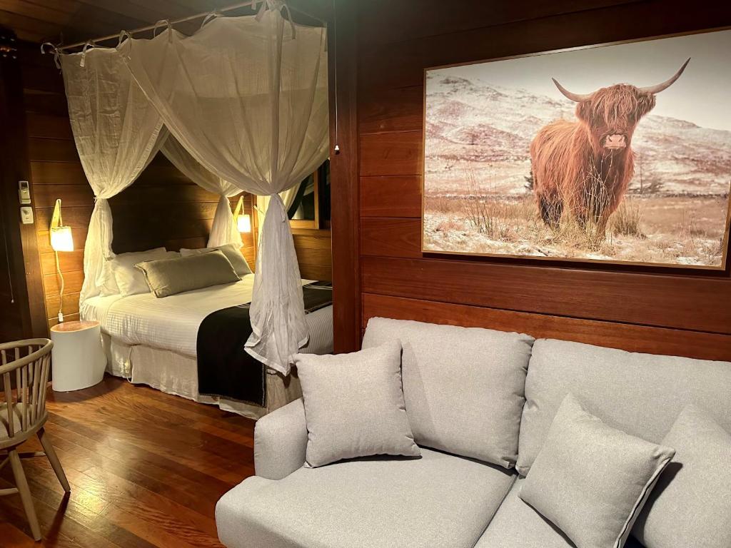 a living room with a couch and a bed with a bull at Koompartoo Retreat Bellingen in Bellingen