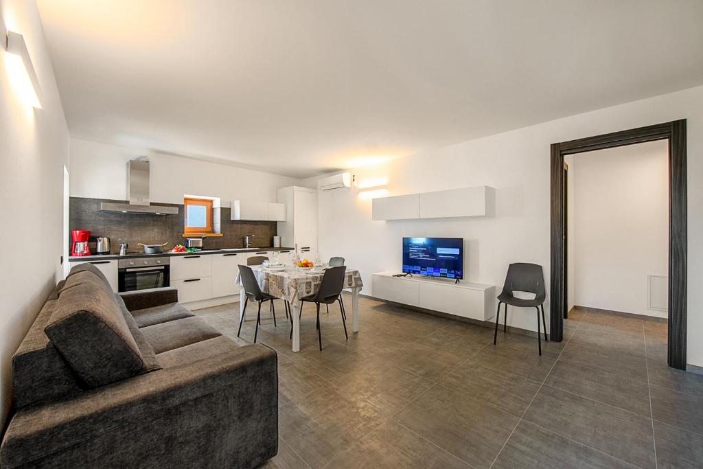 sala de estar con sofá y mesa con sillas en Appartamento Borgo Pastoedo - Happy Rentals en Tenno