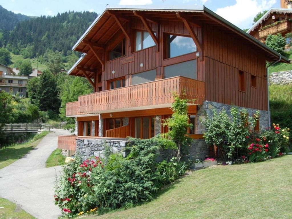 Casa de madera con balcón y algunas flores en 4 6 pers holiday appartment near center of Champagny, en Le Villard