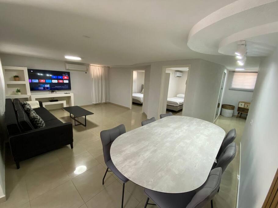 uma sala de estar com uma mesa e um sofá em יחידת קורל בלב הגליל העליון coral unit em Quriate-Chemoná