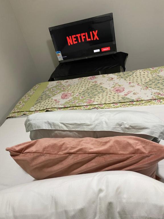 ein Bett mit einer Netflix-Uhr darüber in der Unterkunft Flat Aeroporto vitoria in Vitória