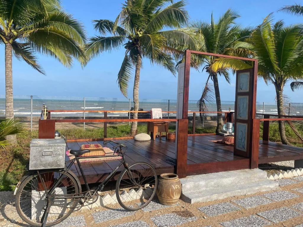 ein Fahrrad, das vor einem Strand mit Palmen geparkt ist in der Unterkunft Blackstone Beach Resort in Kuantan