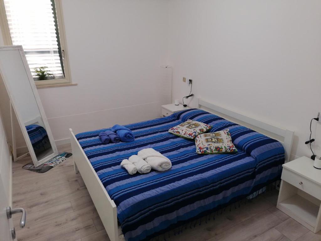 - une chambre avec un lit et des serviettes dans l'établissement Lucky House, à Marina di Ragusa
