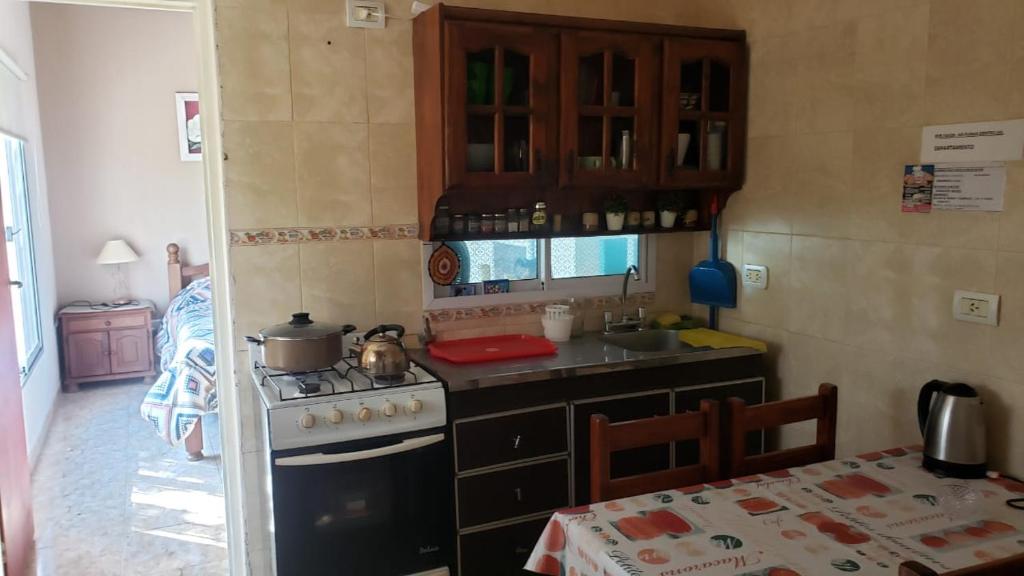 a kitchen with a stove and a sink and a table at Complejo Las chacras in Juana Koslay 