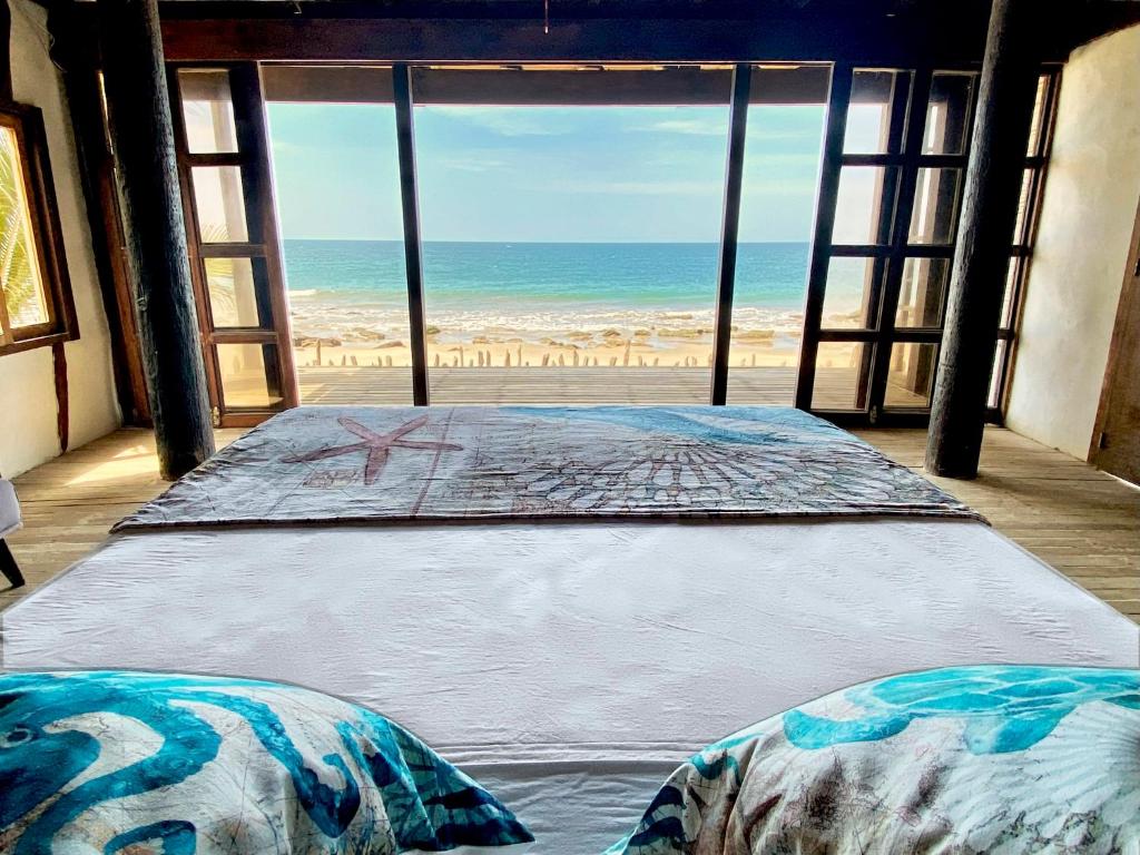 twee bedden in een kamer met uitzicht op het strand bij AYNI in Canoas