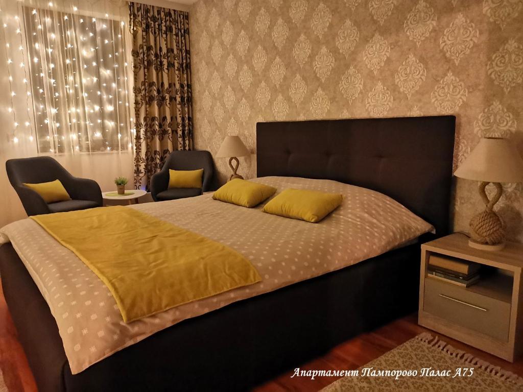 a bedroom with a large bed and two chairs at Apartment Pamporovo Palaсe A75 in Pamporovo