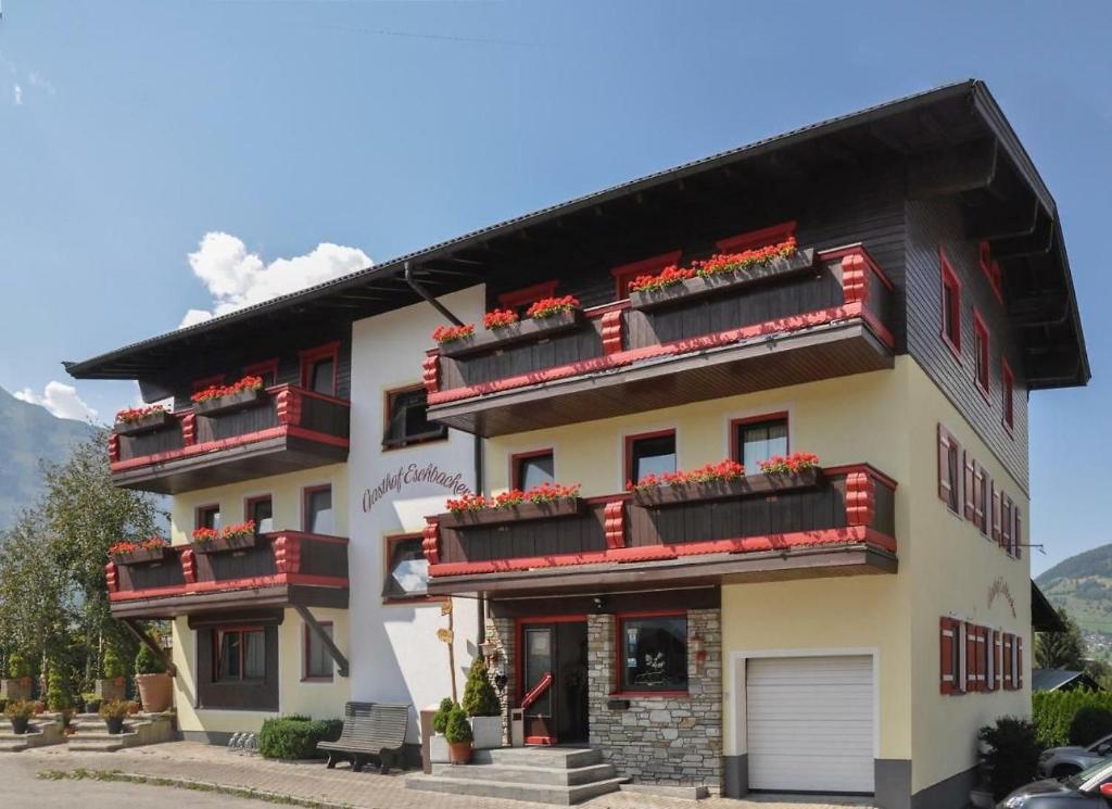 a building with red balconies and flowers on it at sWiesers in Piesendorf