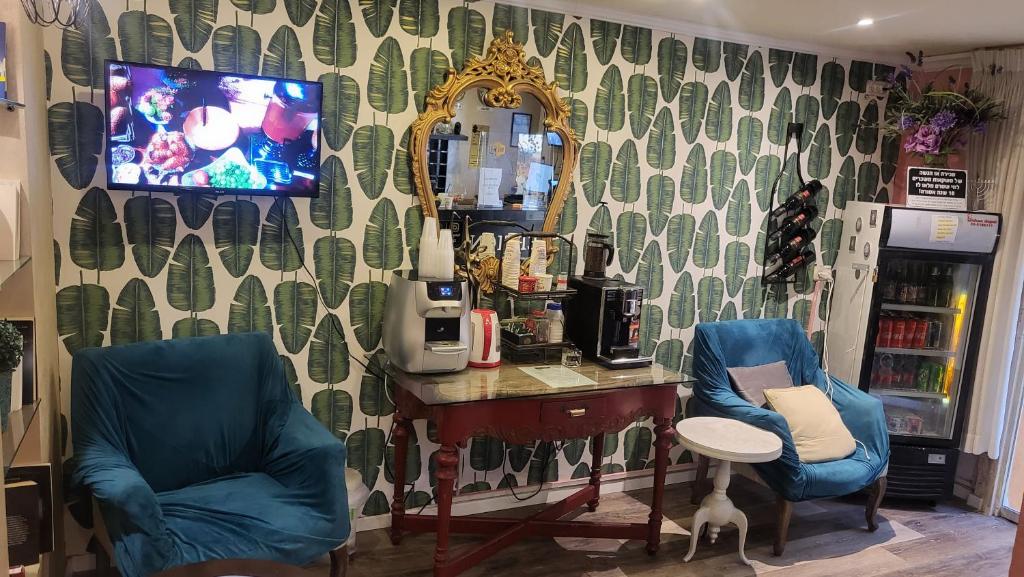 a room with two chairs and a desk and a mirror at Central Hotel in Tel Aviv