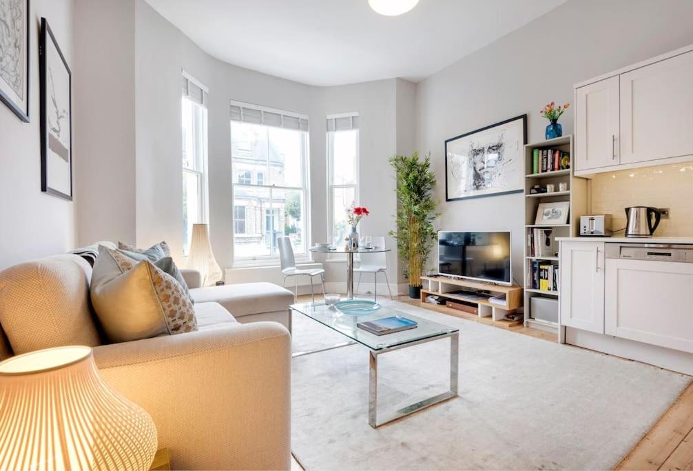 a living room with a couch and a table at Contemporary Clapham Living in London