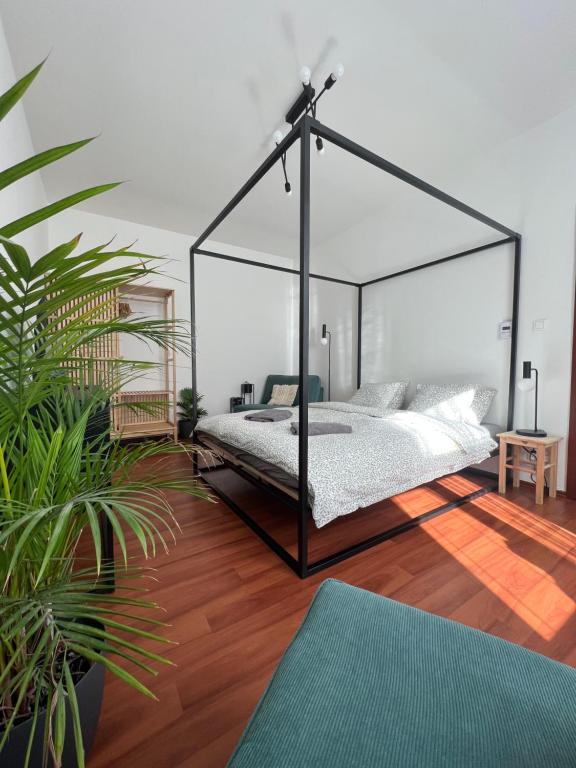 1 dormitorio con cama con dosel y suelo de madera en Sušilova 14 apartments I, en Přerov