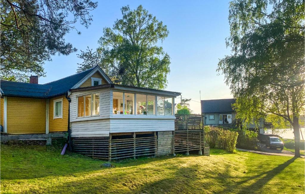 a small yellow house with a porch on a yard at Beautiful Home In Sdertlje With Kitchen in Södertälje