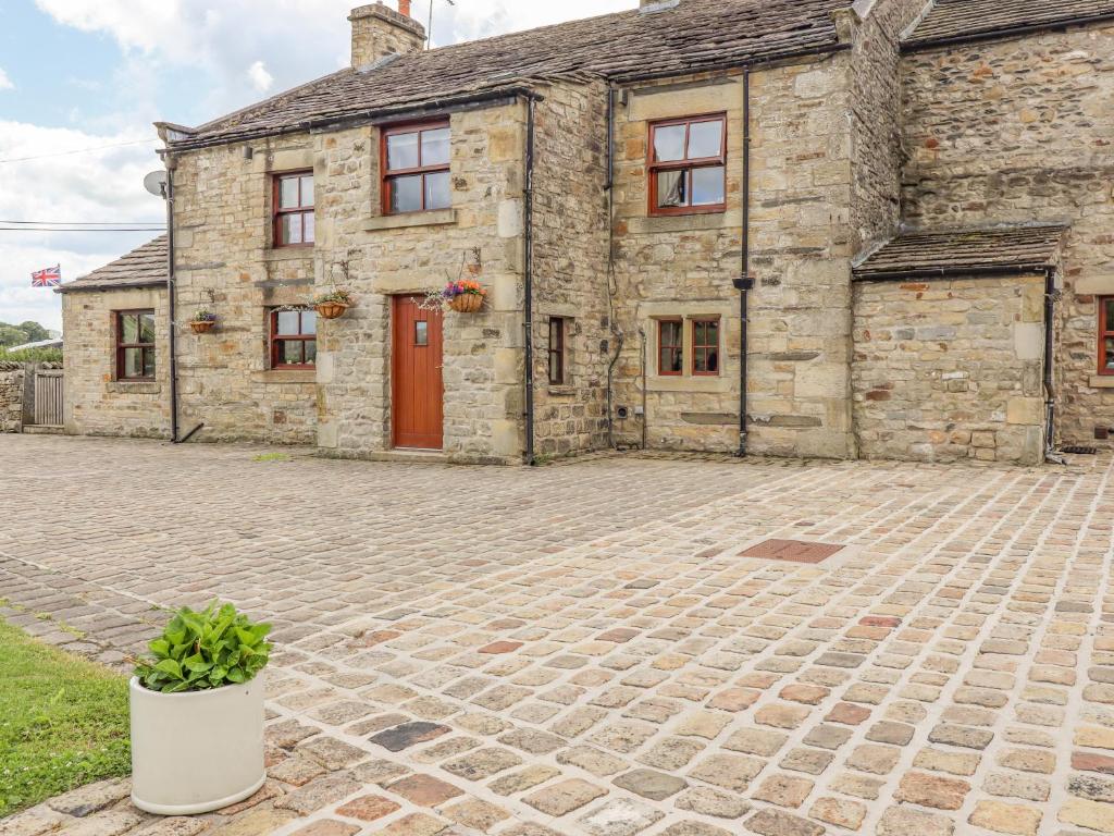 an old stone house with a red door at Orcaber Farmhouse in Lancaster