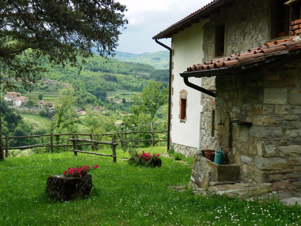 a stone house with a view of a valley at Alluring Farmhouse in Ortignano with Swimming Pool in Castel Focognano