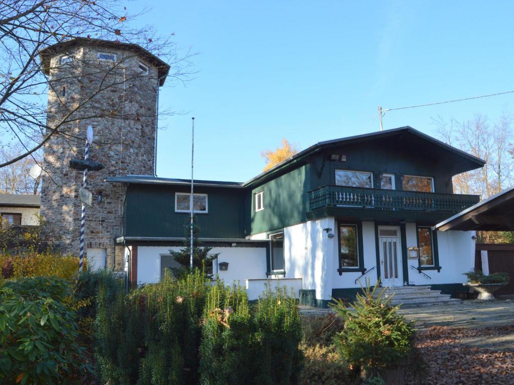 una casa con techo verde y chimenea en Pleasant Holiday Home in Kemmenau with Sauna, en Kemmenau