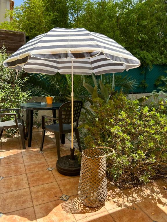 un parapluie noir et blanc assis à côté d'une table dans l'établissement Cosy Studio en résidence privée, à Marseille