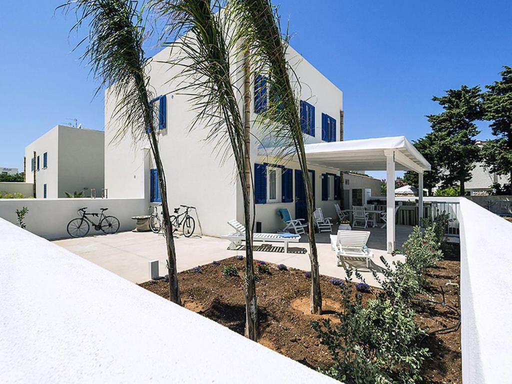 サン・ヴィート・ロ・カーポにあるModern Holiday Home in San Vito Lo Capo with Roof Terraceのヤシの木が目の前に広がる白い家