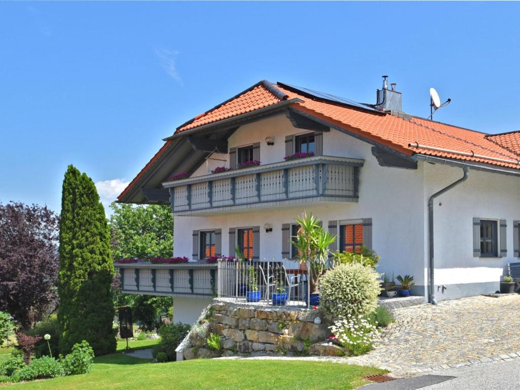 Una gran casa blanca con balcón. en Beautiful apartment in the Bavarian Forest with balcony and whirlpool tub en Waldkirchen