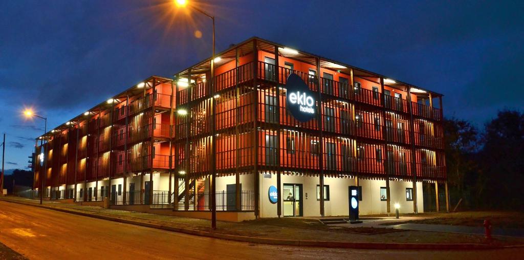 a large building with a sign on the side of it at Eklo Hotels Le Mans in Le Mans