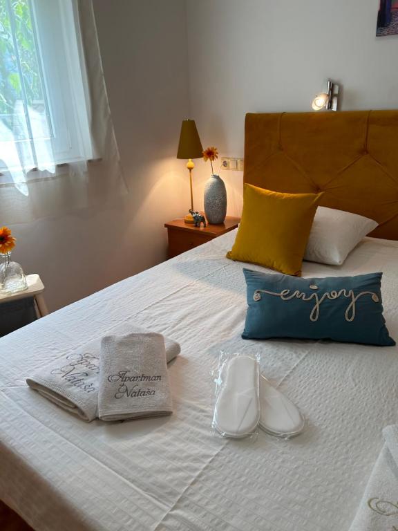 - une chambre dotée d'un lit avec des serviettes et des chaussures dans l'établissement Apartment Natasa, à Rab