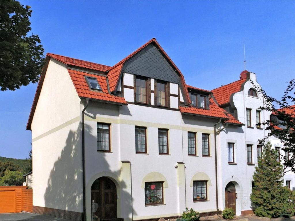 ein großes weißes Haus mit orangefarbenem Dach in der Unterkunft Cosy and comfortable holiday home in the Harz region in Thale
