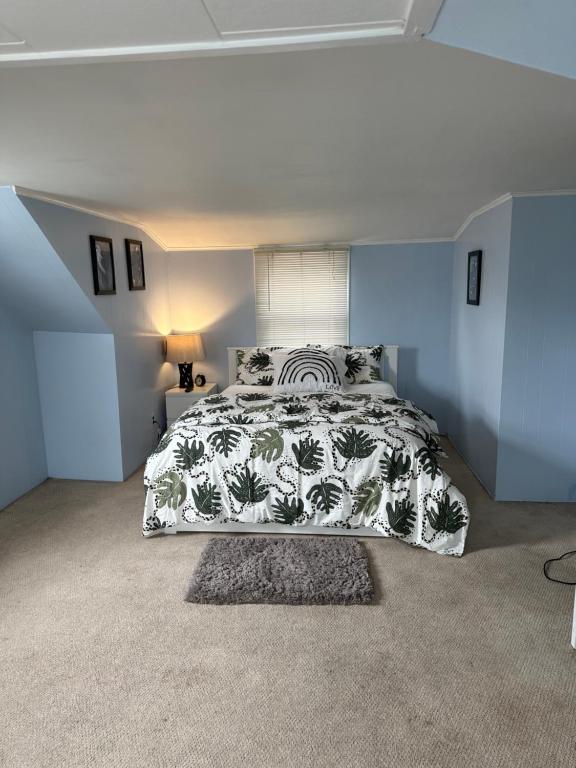 a bedroom with a bed with a black and white bedspread at Destiny’s Place in Franklin Square