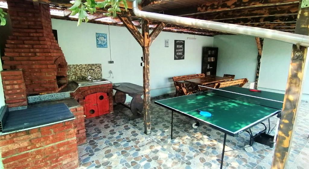 uma mesa de pingue-pongue num quarto com um forno de tijolos em Casa Noastră em Cricău