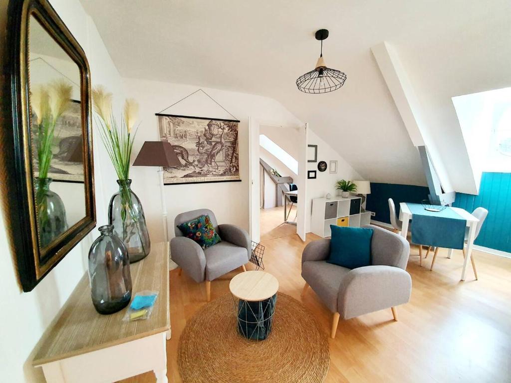 un salon avec deux chaises et une table dans l'établissement Chic Studio Sous Les Toits du Centre Historique, à Vannes