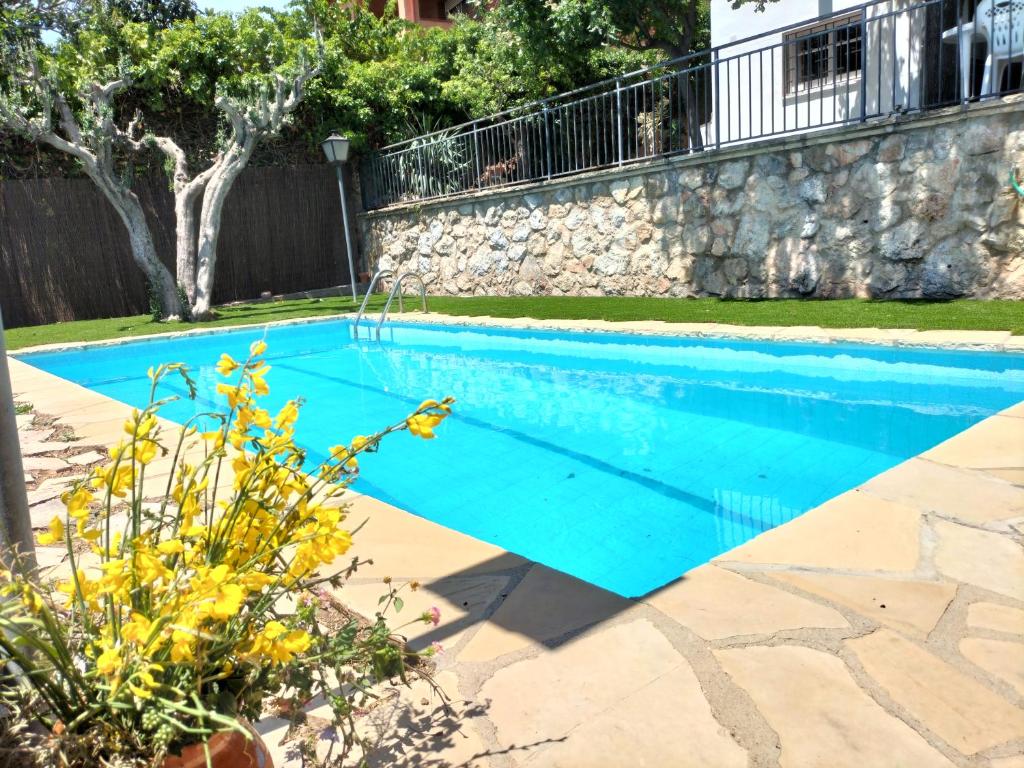 una piscina con acqua blu in un cortile di Casa Flor de Taronger a Viladecáns