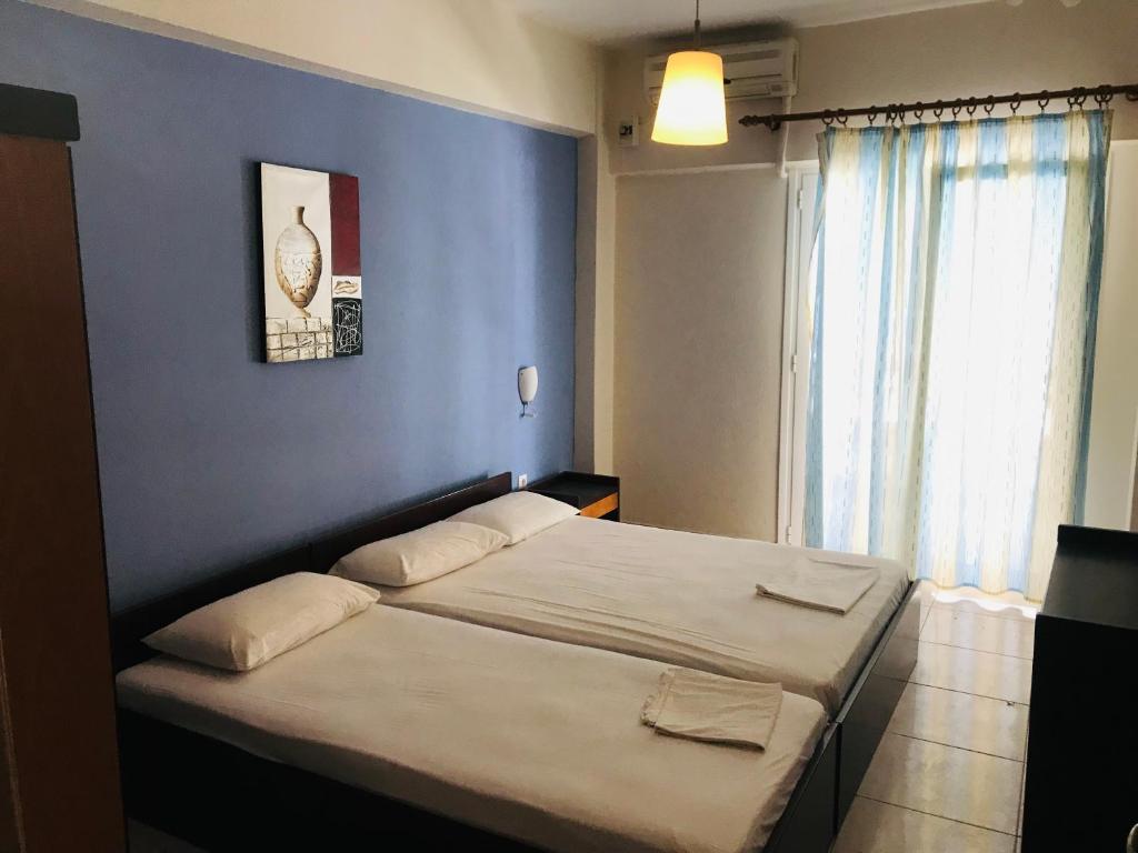 a bedroom with a bed with a blue wall at Apartment Vasco in Paralia Katerinis