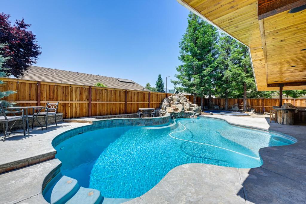 una piscina en un patio trasero con una valla de madera en California Vacation Rental with Private Pool and Patio, en Visalia