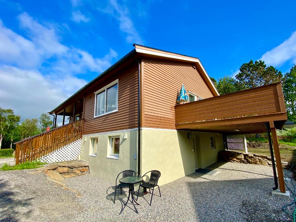 una casa con 2 sillas y un edificio en Cozy apartment Leknes Lofoten, en Leknes