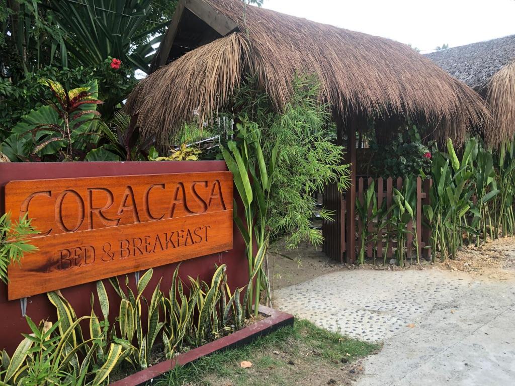 a sign in front of a resort with a thatch hut at Coracasa bed and breakfast in General Luna