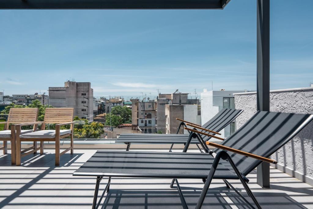 two chairs and a table on the roof of a building at Starlight Residence in Athens