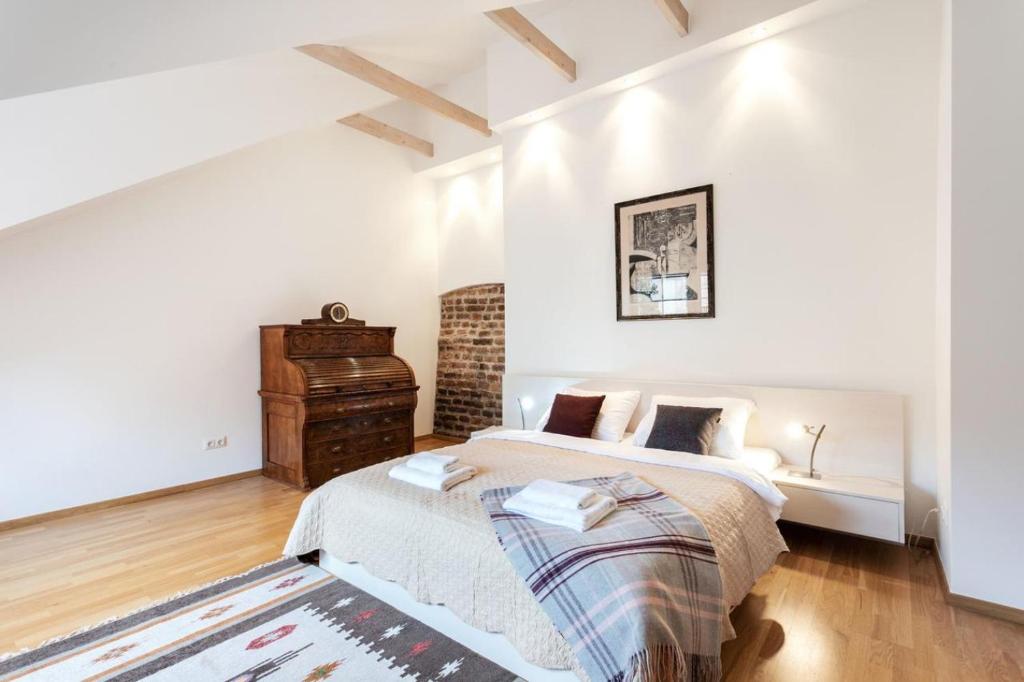 a white bedroom with a bed and a dresser at Saint John 2 Bedroom Cottage by Reside Baltic in Vilnius