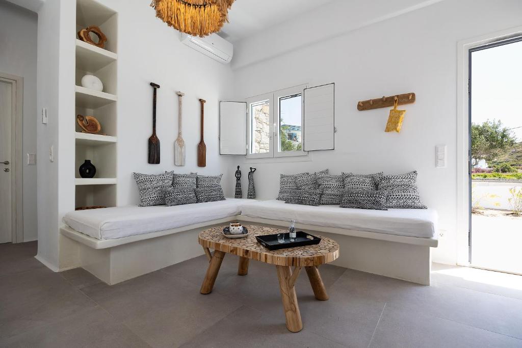 Sala de estar blanca con sofá y mesa en OLIVES seaside villas (4elies) en Plaka