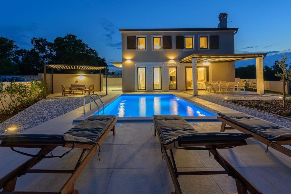 a swimming pool in the backyard of a house at Villa Laura Mia by IstriaLux in Juršići